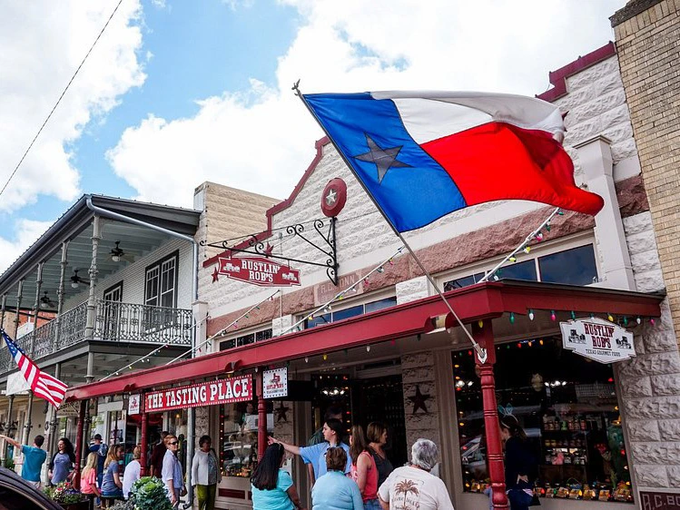 The Texas flag waves outside Rustlin' Rob's tasting storefront on historic Main Street in Fredericksburg, Texas.