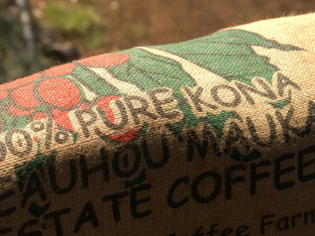 Close-up of a coffee bag labeled '100% Pure Kona Mauka Estate Coffee' with red and green graphics.