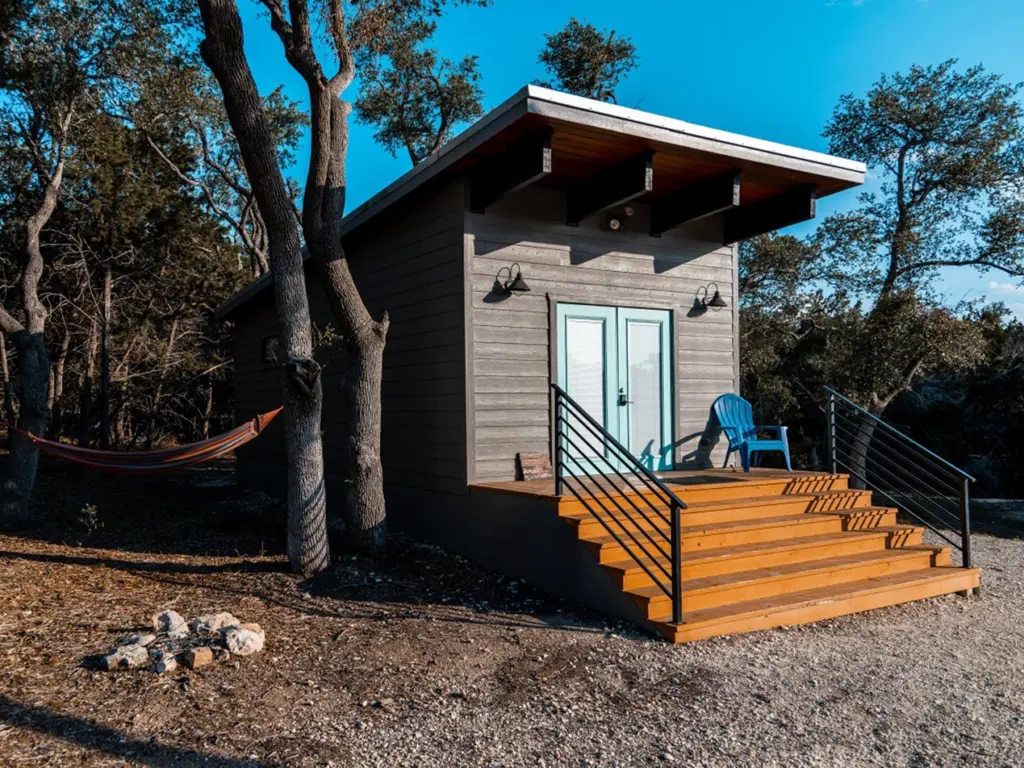 A modern cabin with a light blue door at The Liney Moon, a unique stay for a texas travel itinerary.