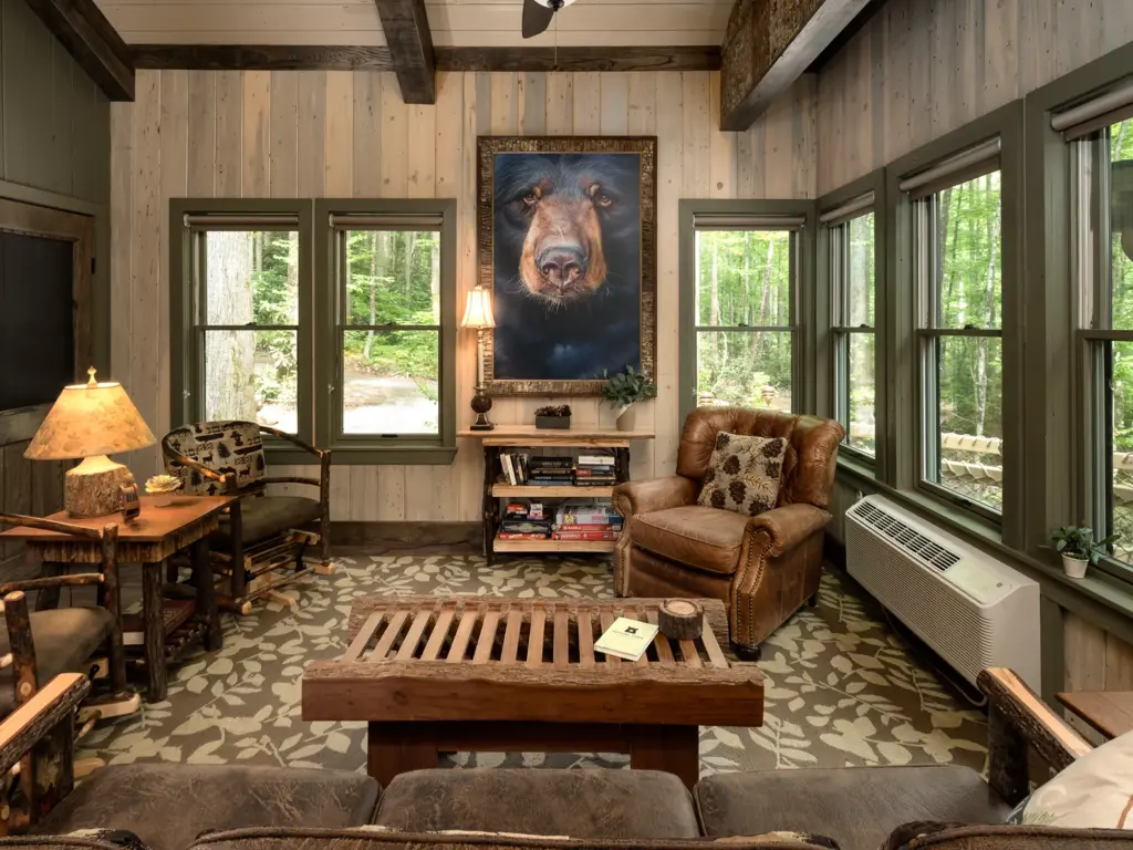 The Treehouse living room at Huffman Creek Retreat featuring rustic furniture and a large black bear painting.