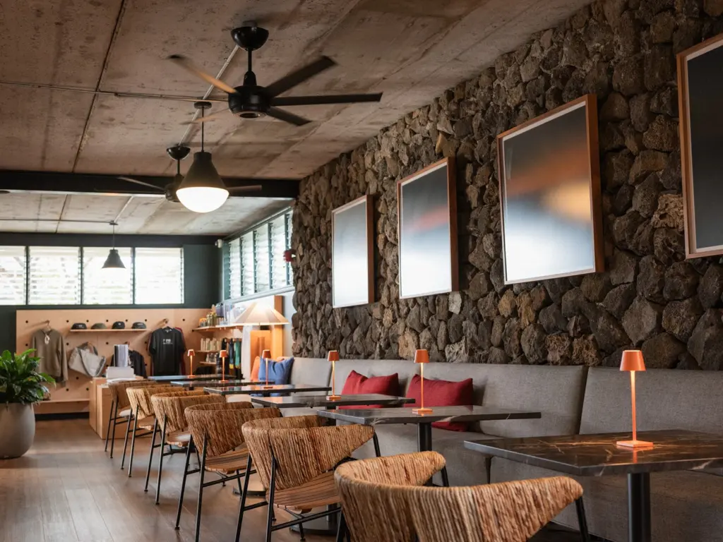 Lounge seating with woven chairs and a stone wall featured at one of the design hotels kailua kona.