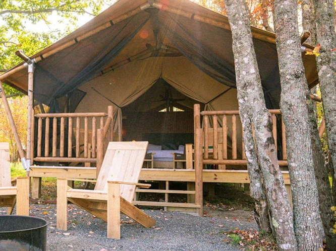 Upscale wilderness retreats northeast showcase luxury canvas glamping tents built on elevated wooden platforms.