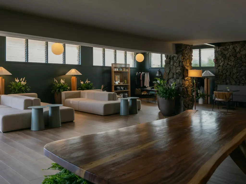 Spacious lobby lounge featuring a large live edge wooden table, stone pillars, and modern seating.
