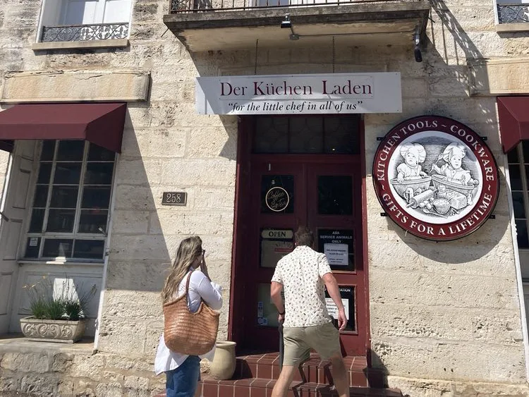 Two people entering Der Küchen Laden, one of the charming shops in Fredericksburg TX.