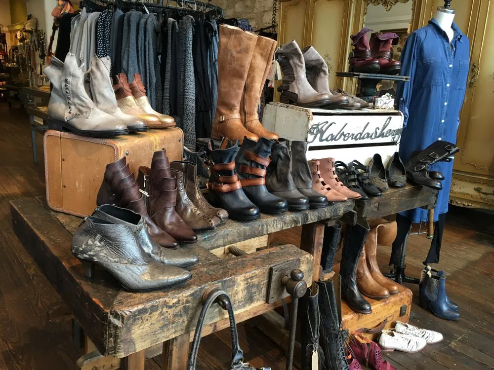 Rustic wooden workbench displaying leather boots and shoes inside a shops in fredericksburg tx boutique.