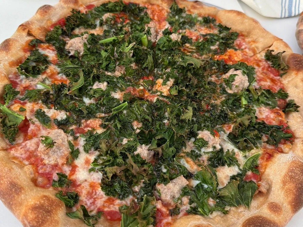 A kale and sausage pizza at Prometheus Pizza, one of the best restaurants in fredericksburg tx.