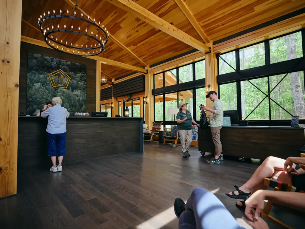 Lodge lobby with forest views and wood-beam ceilings, ideal for nature immersive corporate offsites and staff check-in.