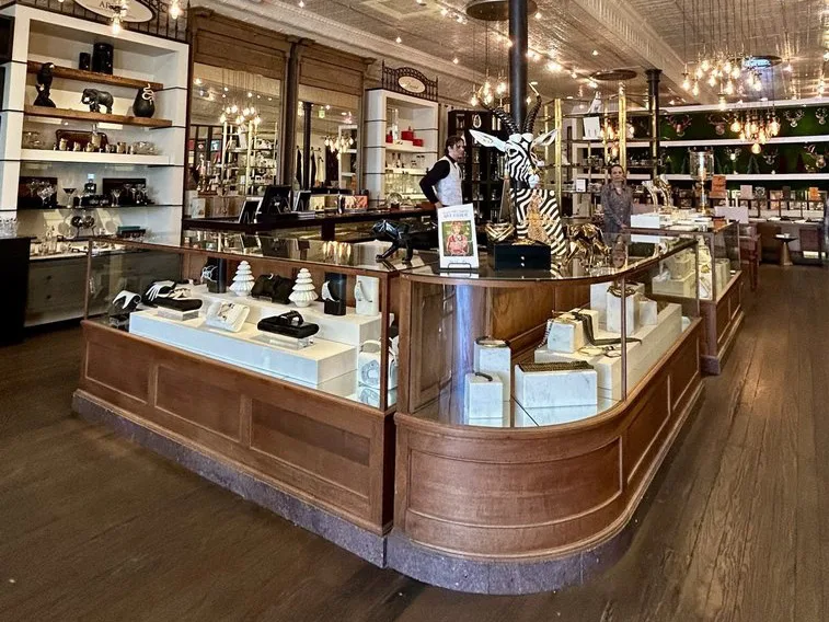Cozy shops in Fredericksburg TX feature warm string lights, wood display cases, and charming decor like this zebra sculpture.