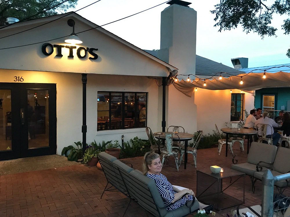 Guests dine on the patio under string lights at Otto's, one of the best restaurants in fredericksburg tx.