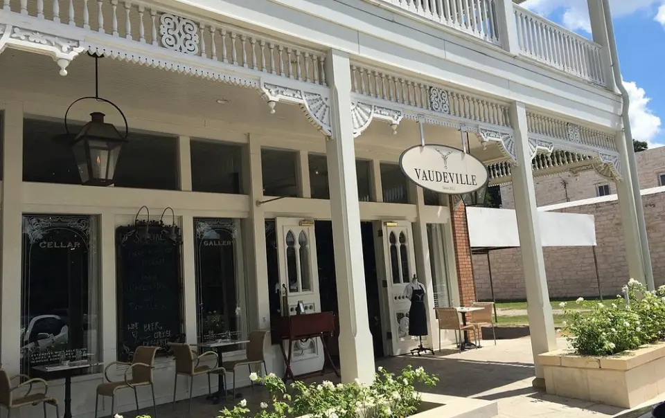 The historic white exterior of Vaudeville, considered one of the best restaurants in fredericksburg tx.